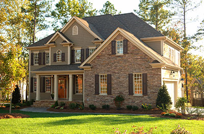 a large brick building with grass in front of a house